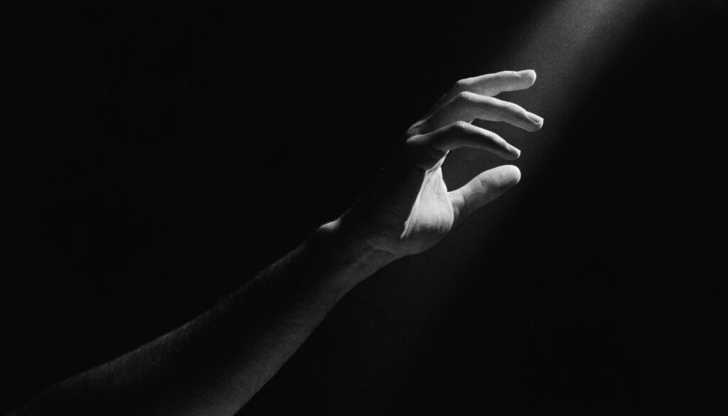 Mão de maestro num facho de luz — direção criativa